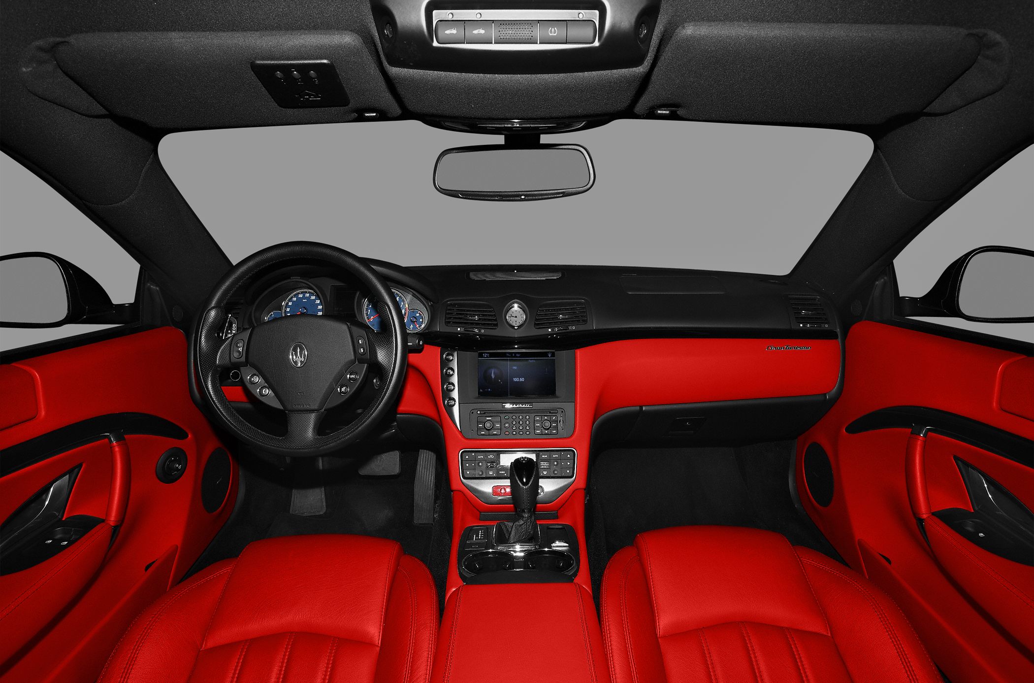 Luxury car interior with red leather seats and dashboard, advanced steering wheel and multimedia console