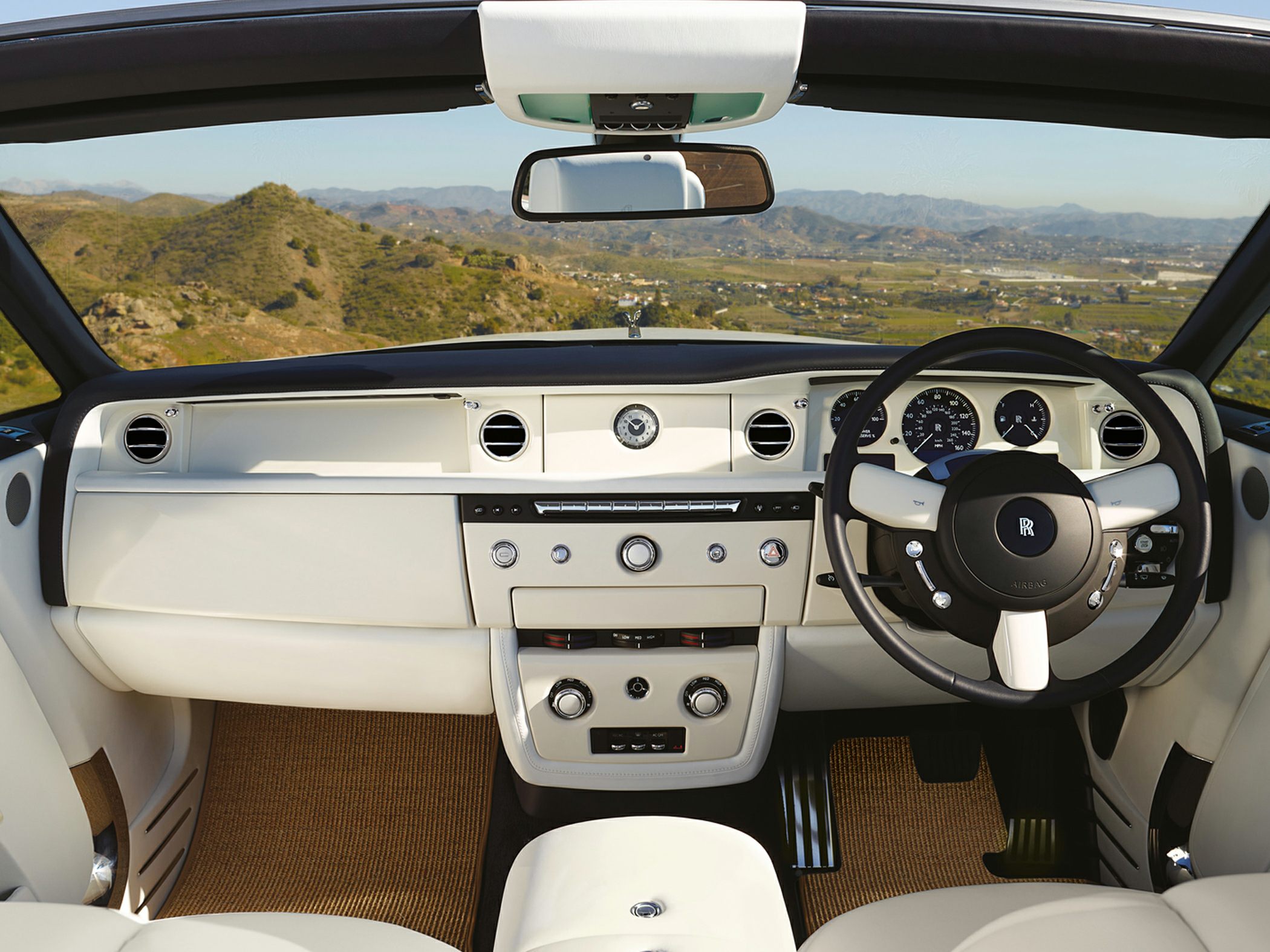 Luxury convertible interior with analog clock and multifunction steering wheel
