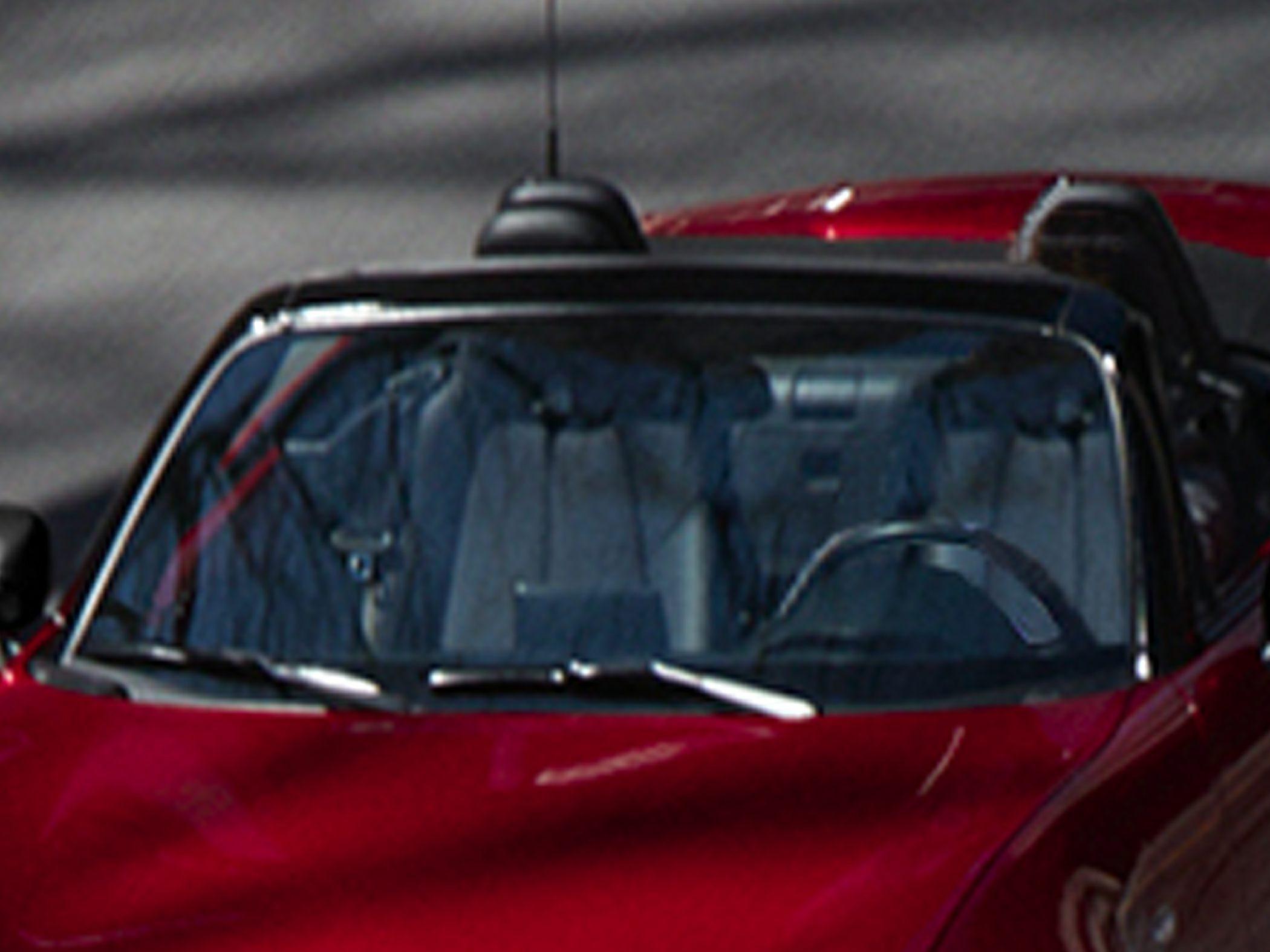 Convertible roadster windshield with interior and steering wheel visible