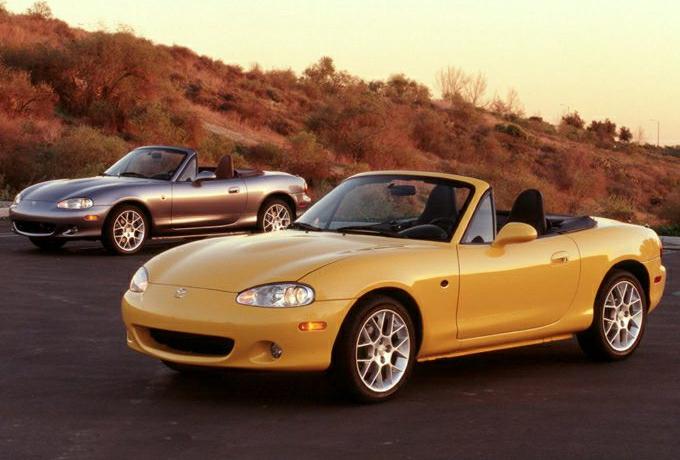 Two sporty Mazda MX-5 II (NB) convertible roadsters parked outdoors