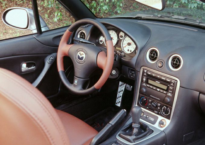 Interior dashboard and steering wheel with manual gearshift and round air vents