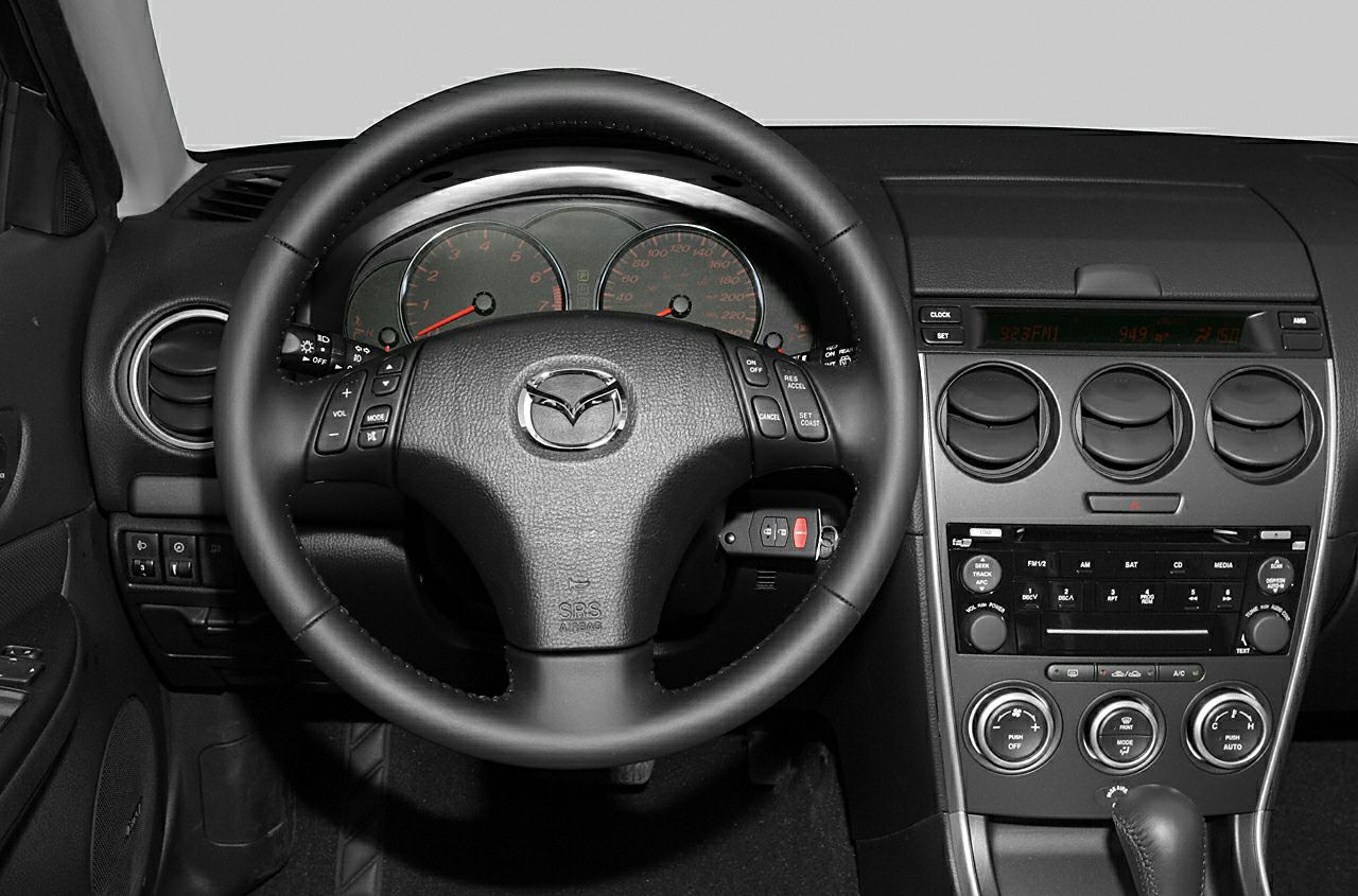 Steering wheel with controls and dashboard with instrument cluster and air vents
