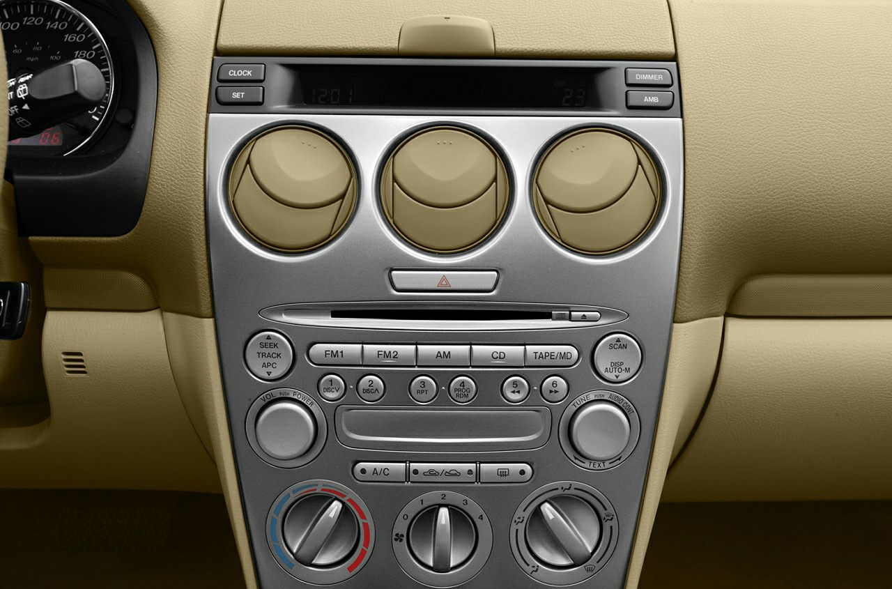 Beige dashboard center console with air vents, climate controls, and radio interface.