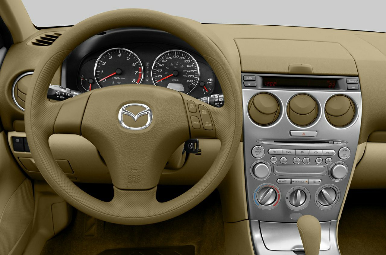 Steering wheel and dashboard of a vintage car interior with instrument panel and control knobs
