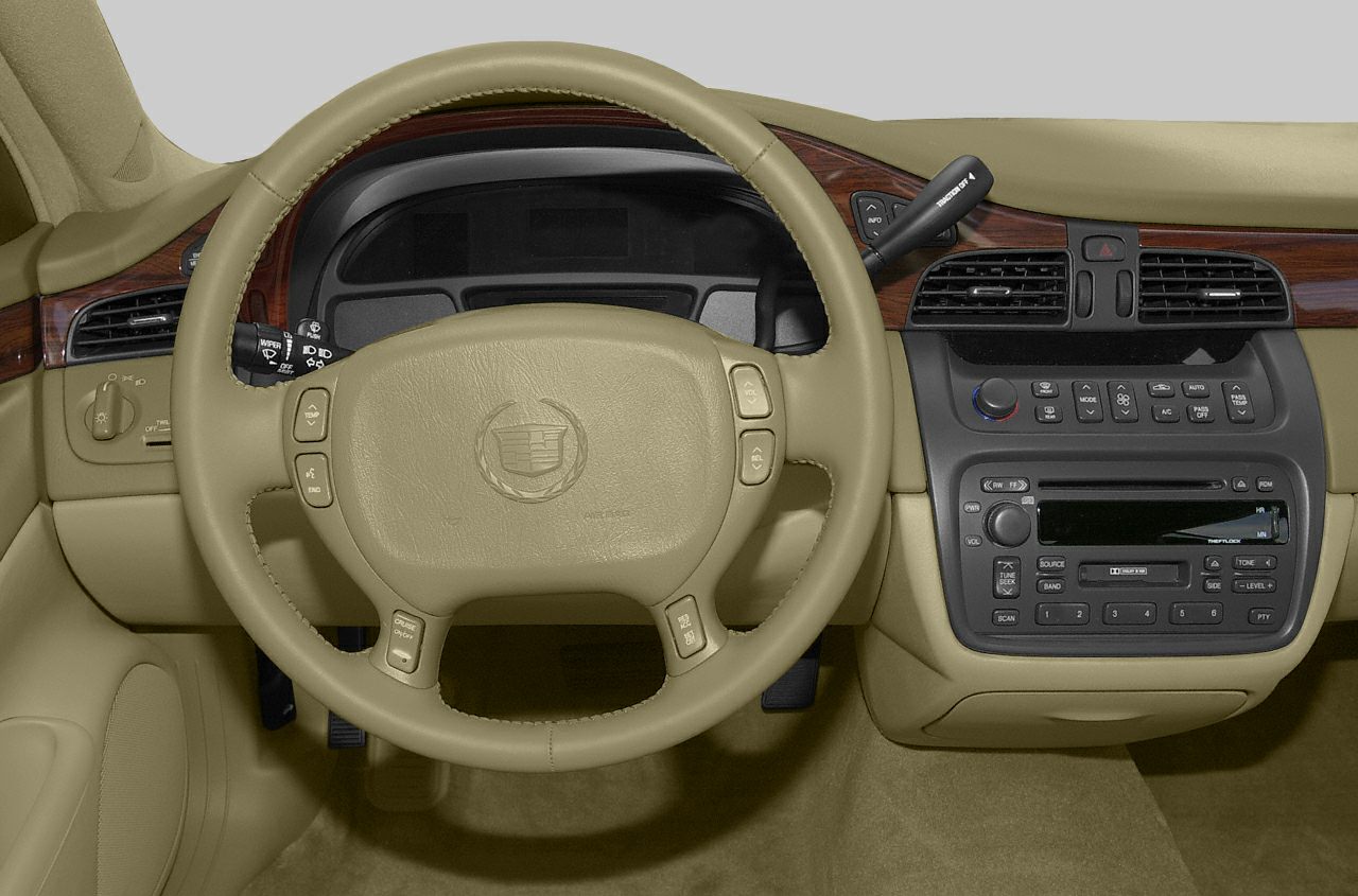 Beige leather steering wheel and detailed dashboard with wood trim