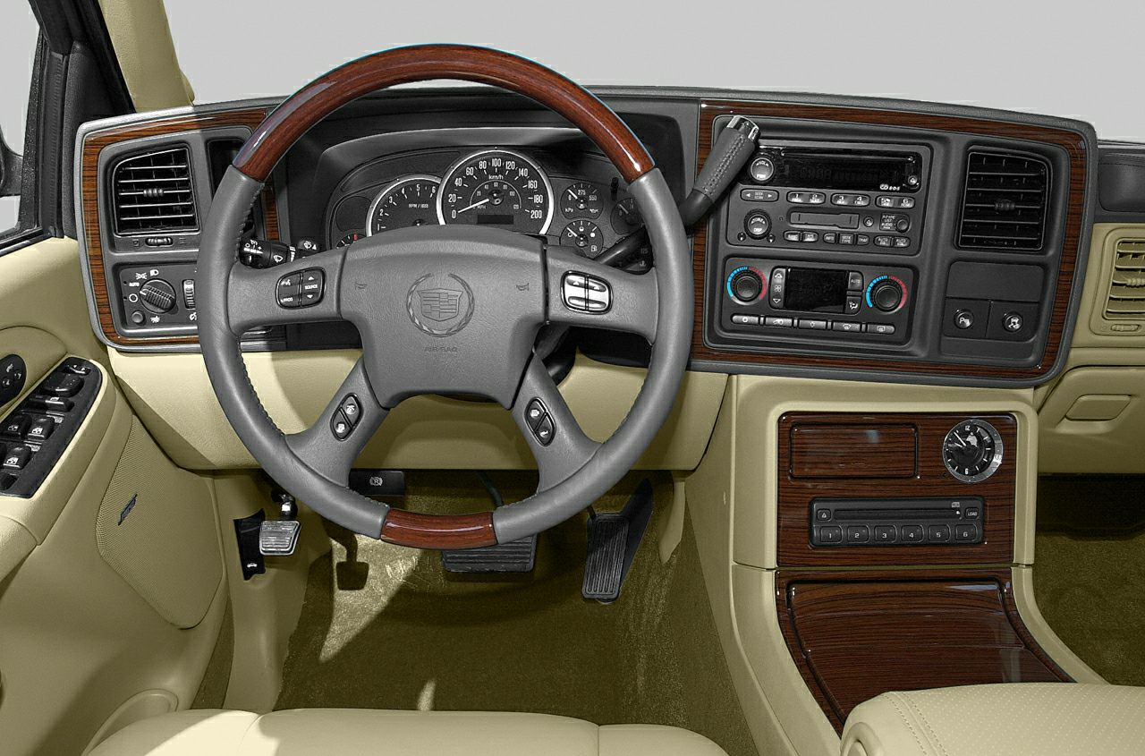 Wood-trimmed steering wheel and beige dashboard with control panels