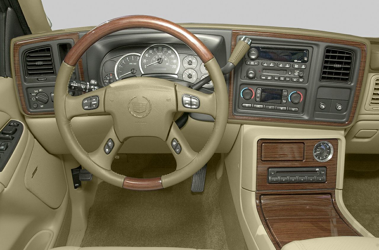 Wood-trimmed steering wheel and classic dashboard controls with gauges and climate settings