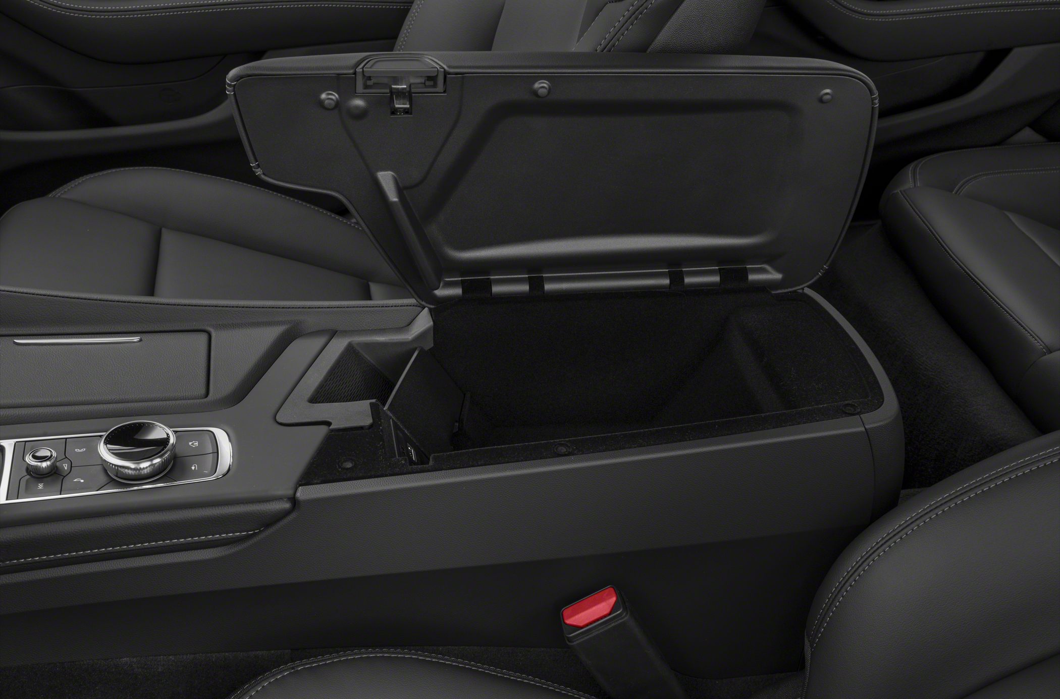 Open center console storage compartment with black interior upholstery.