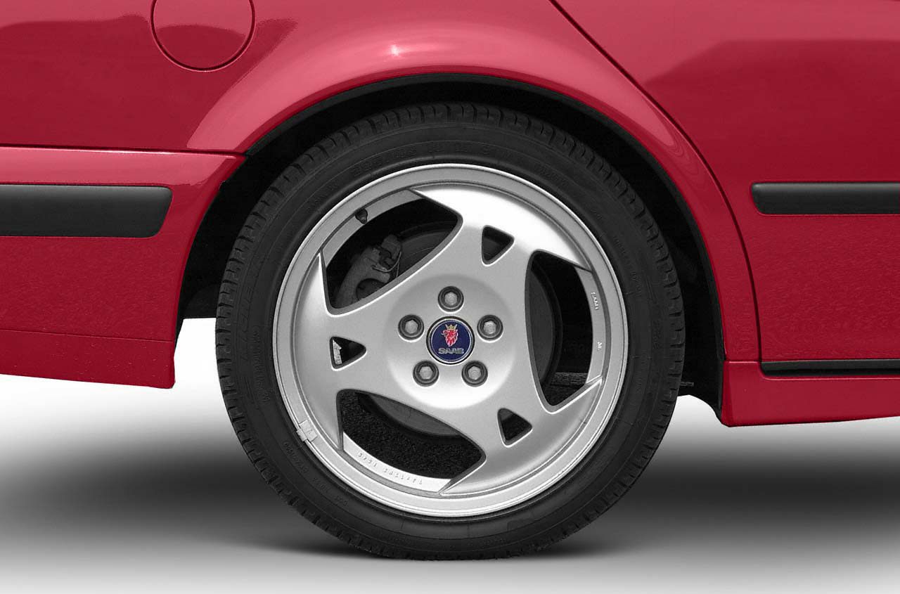 Close-up of five-spoke alloy wheel and rear side panel with fuel cap.