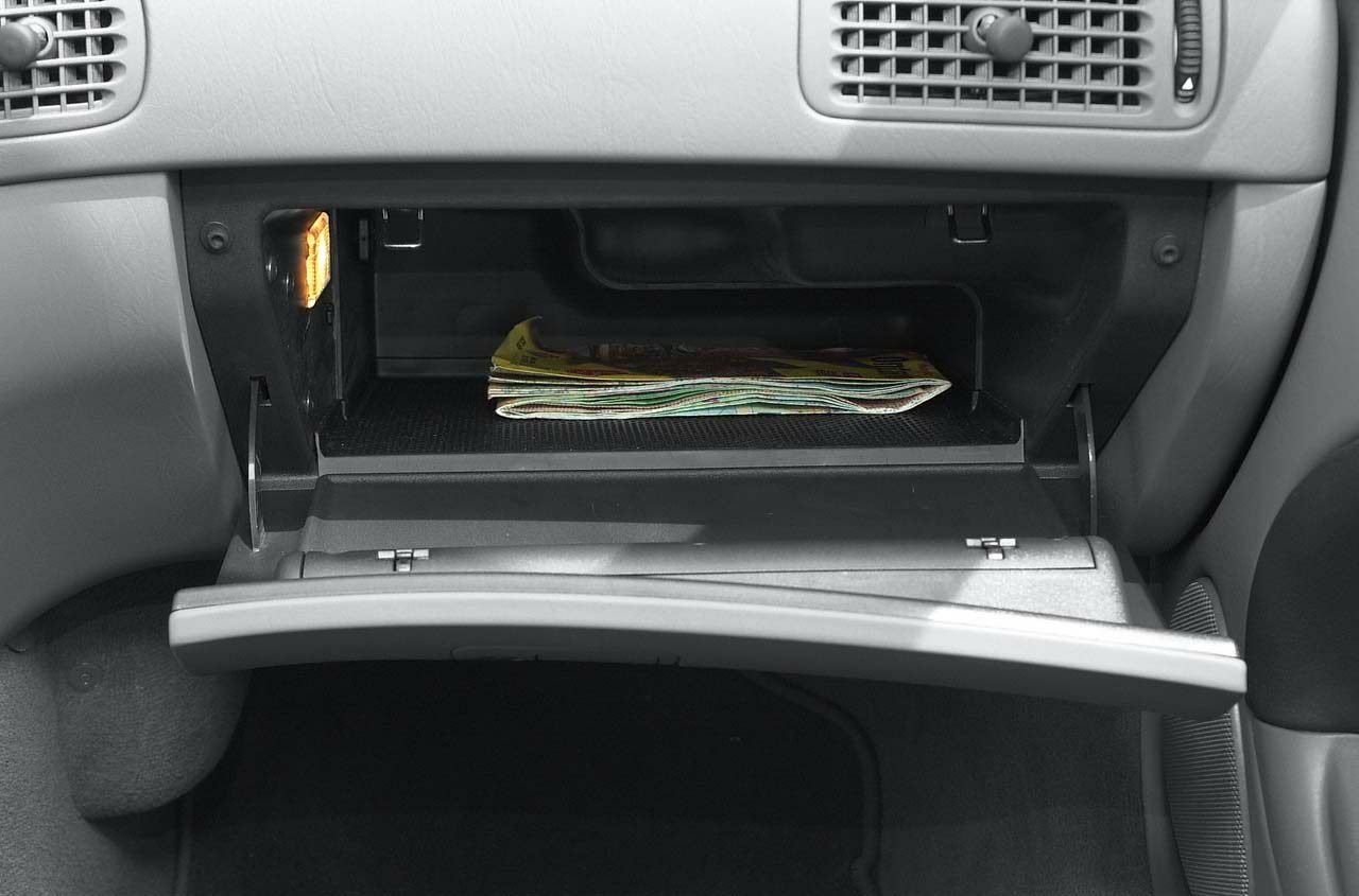 Open glove compartment with interior light and folded papers