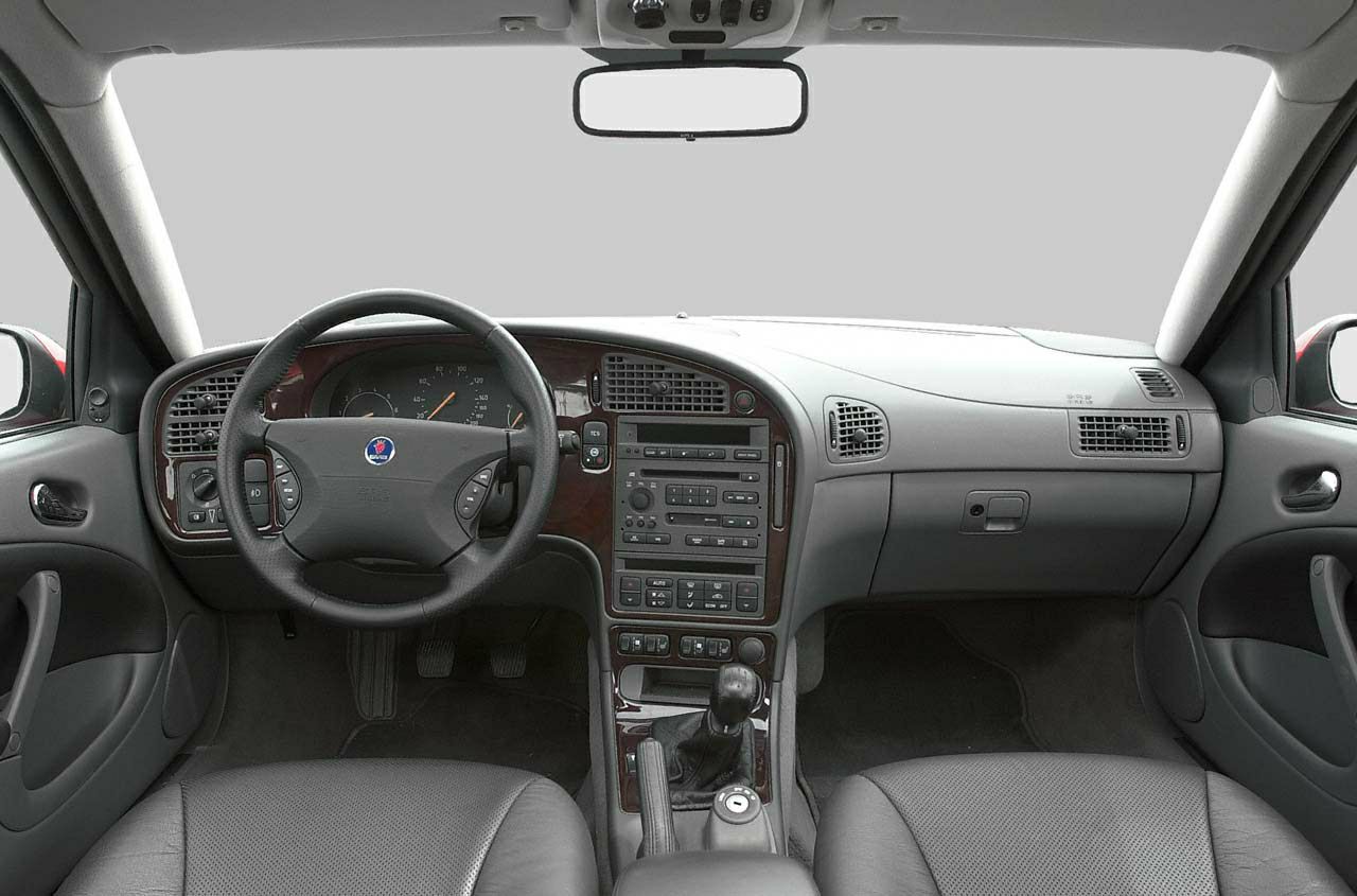 Car interior dashboard, steering wheel, central console with wood trim