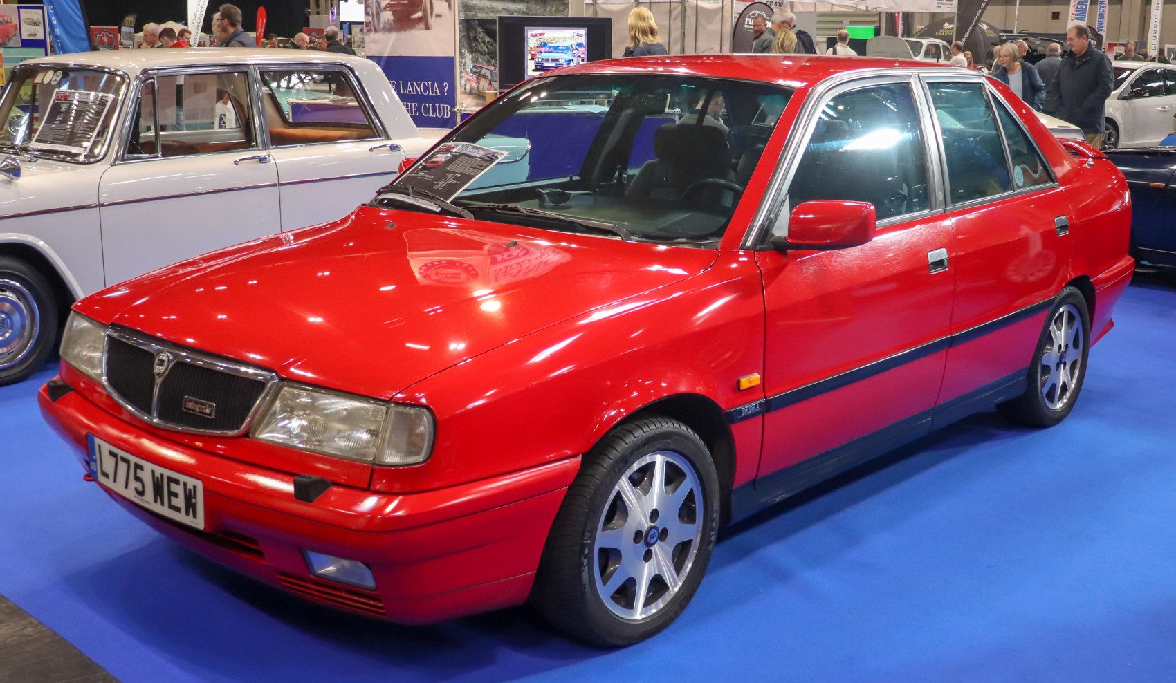 Red four-door sedan with alloy wheels and prominent front grille