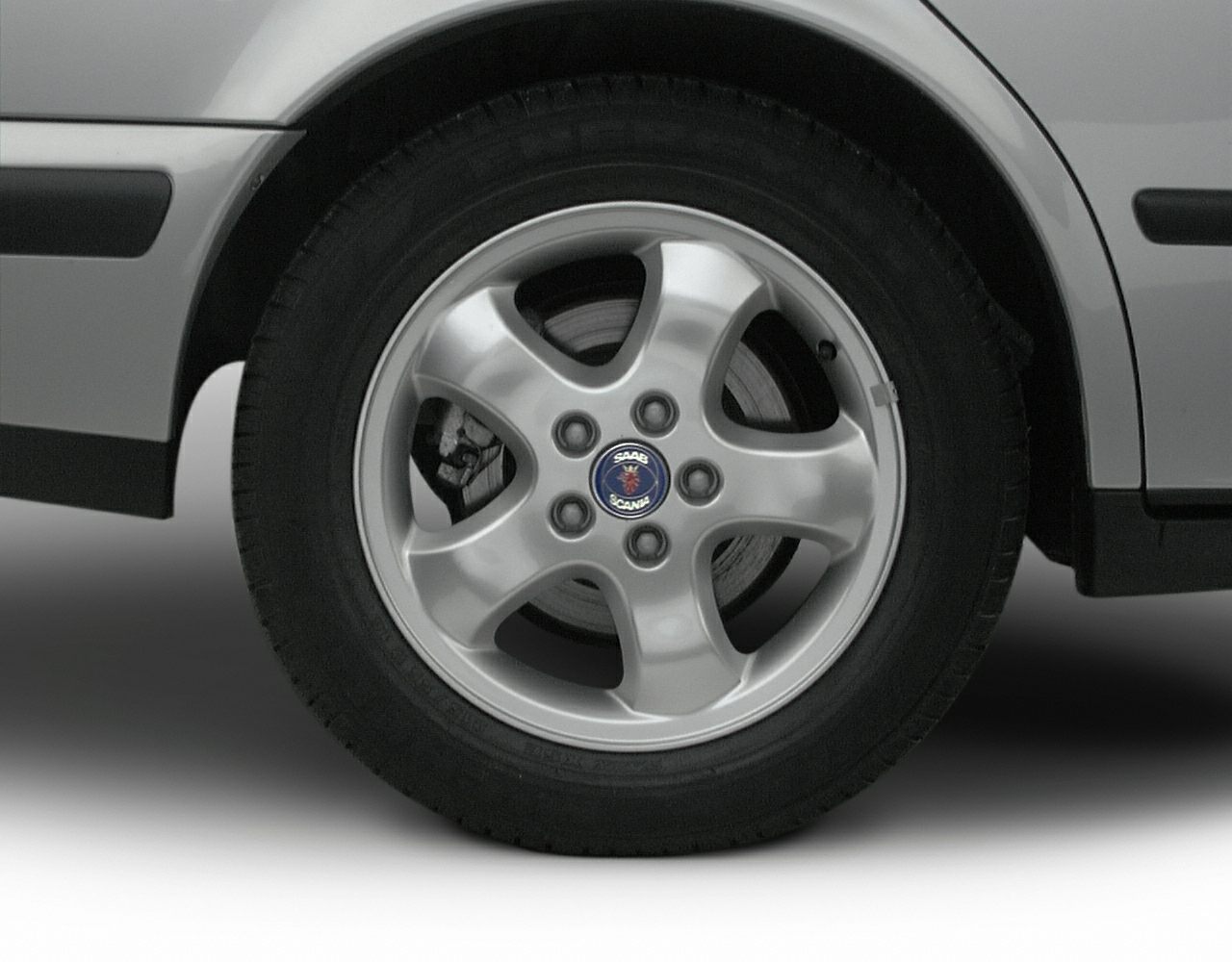 Close-up of five-spoke alloy wheel with brake disc and Saab logo center cap