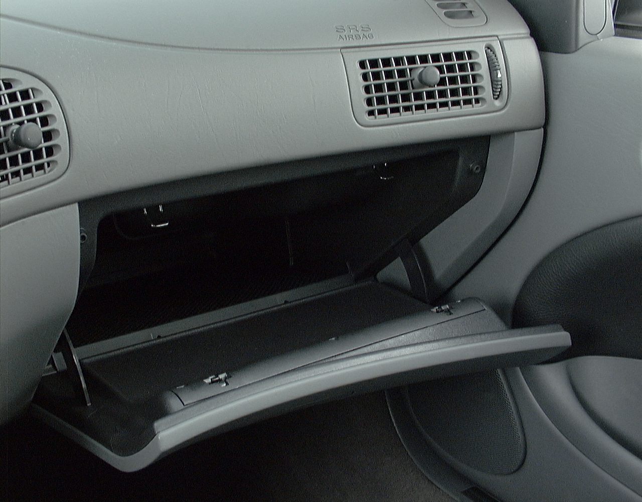 Open glove box and dashboard air vents in car interior