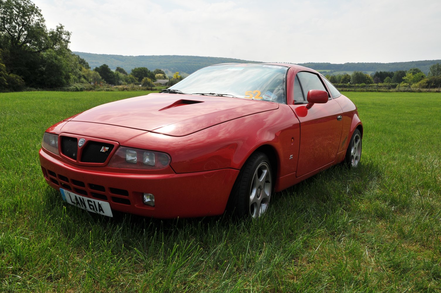 Sleek front and side view of a sports coupe with hood vent.