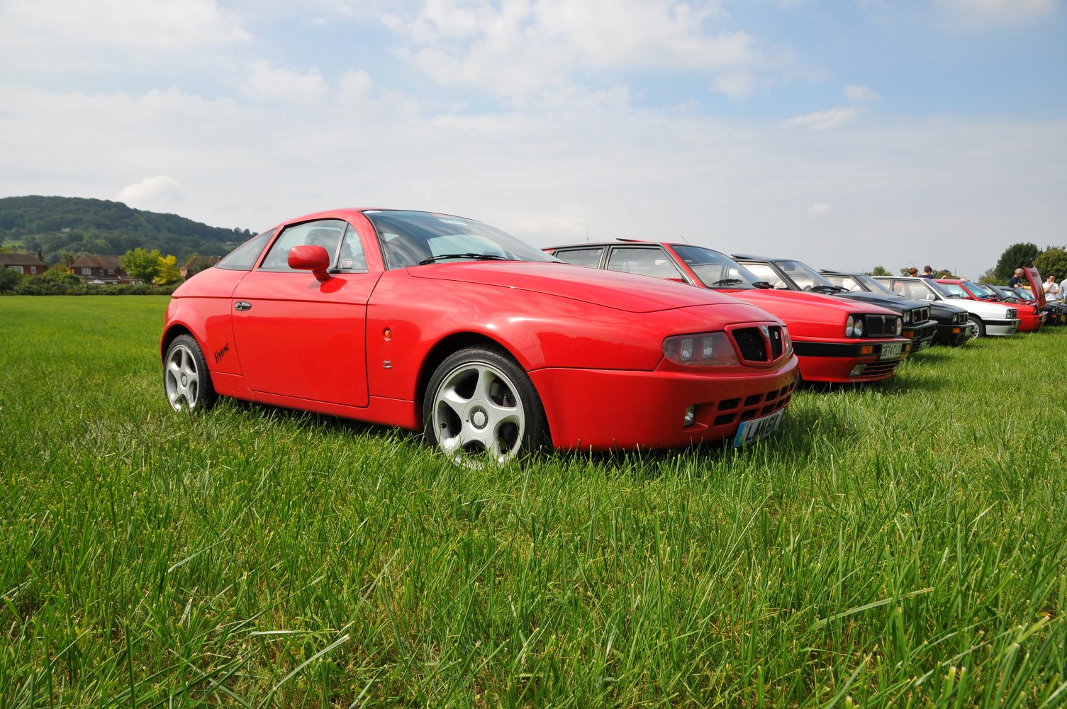 Red sporty coupe with sleek body and distinctive front grille