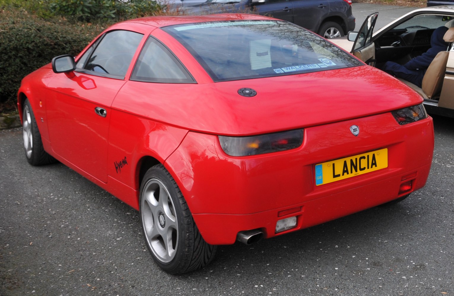 Sporty red coupe with distinctive rear styling and alloy wheels.