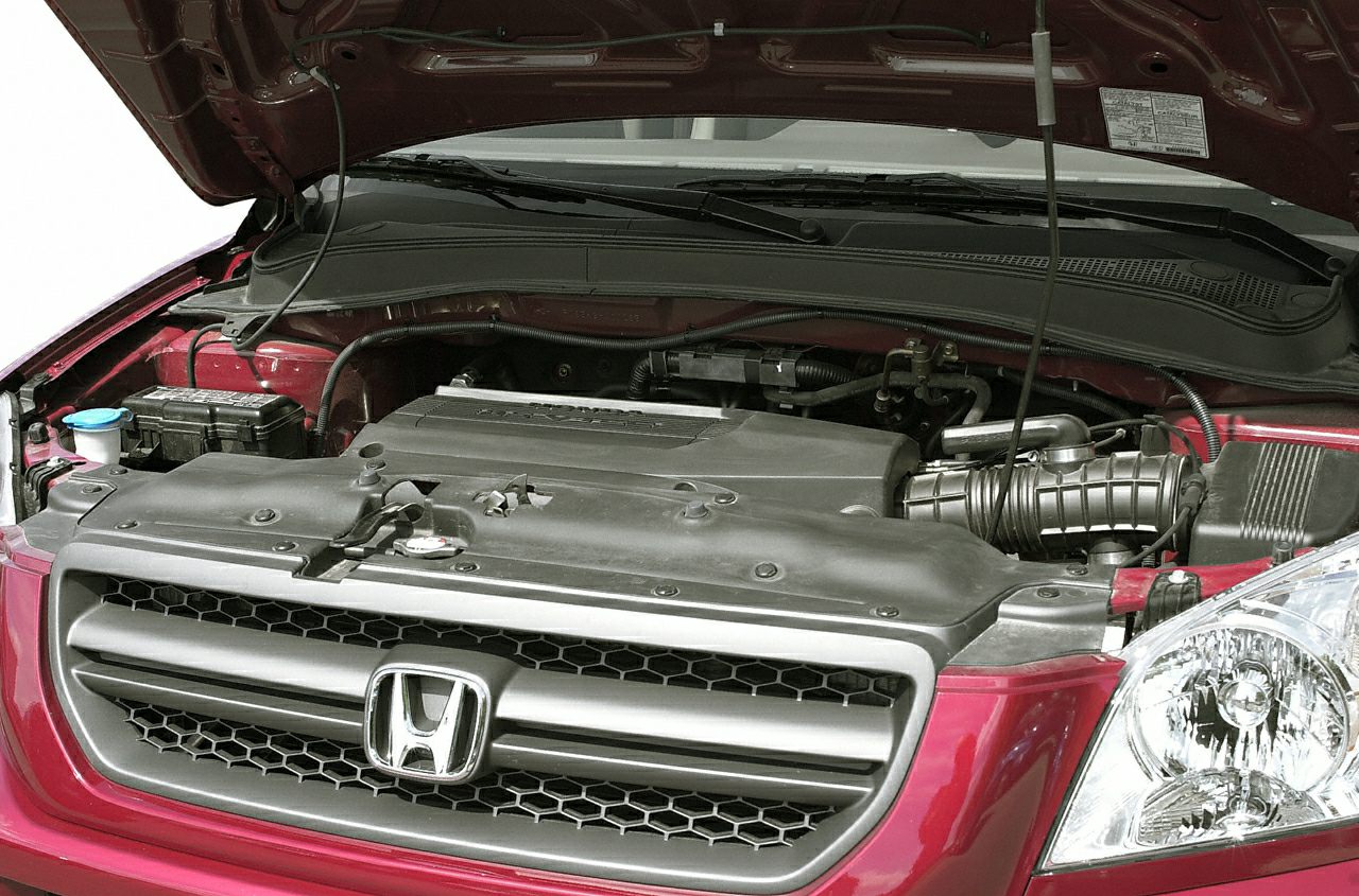 Open hood showing engine bay, front grille, and headlight of SUV