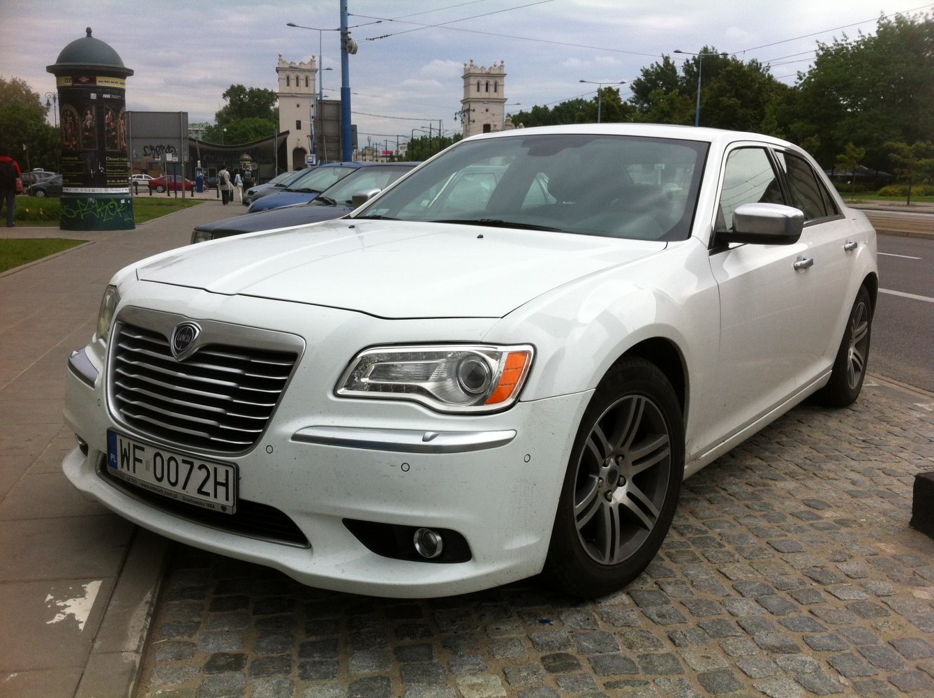 White luxury sedan with distinctive grille and LED headlights.