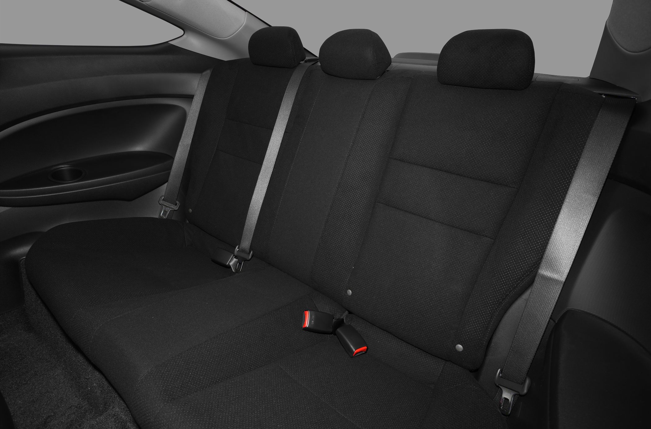 Rear seat with black upholstery, headrests, and seat belts