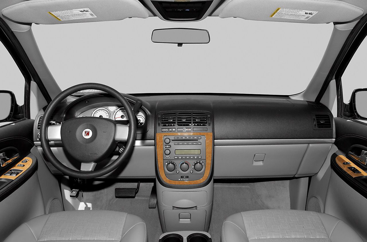 Dashboard with wood trim, analog gauges, and steering wheel with emblem.