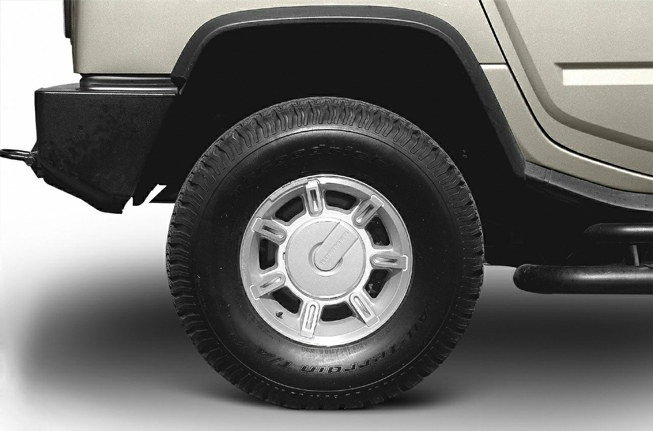 Close-up of rugged tire and wheel with fender and side panel.