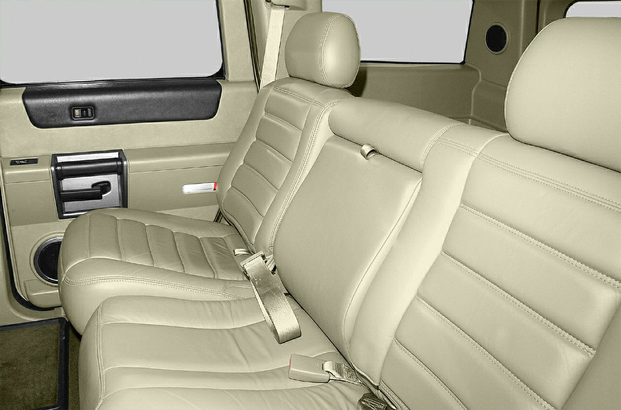 Rear seat with tan leather upholstery and door panel with built-in speaker