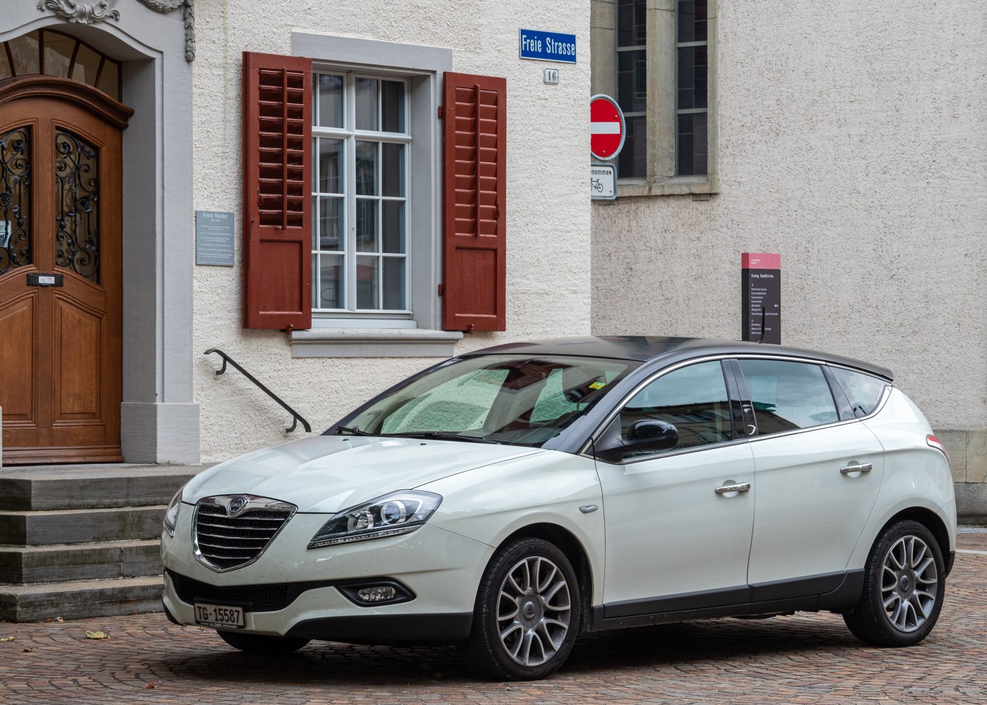 White hatchback with black roof and alloy wheels