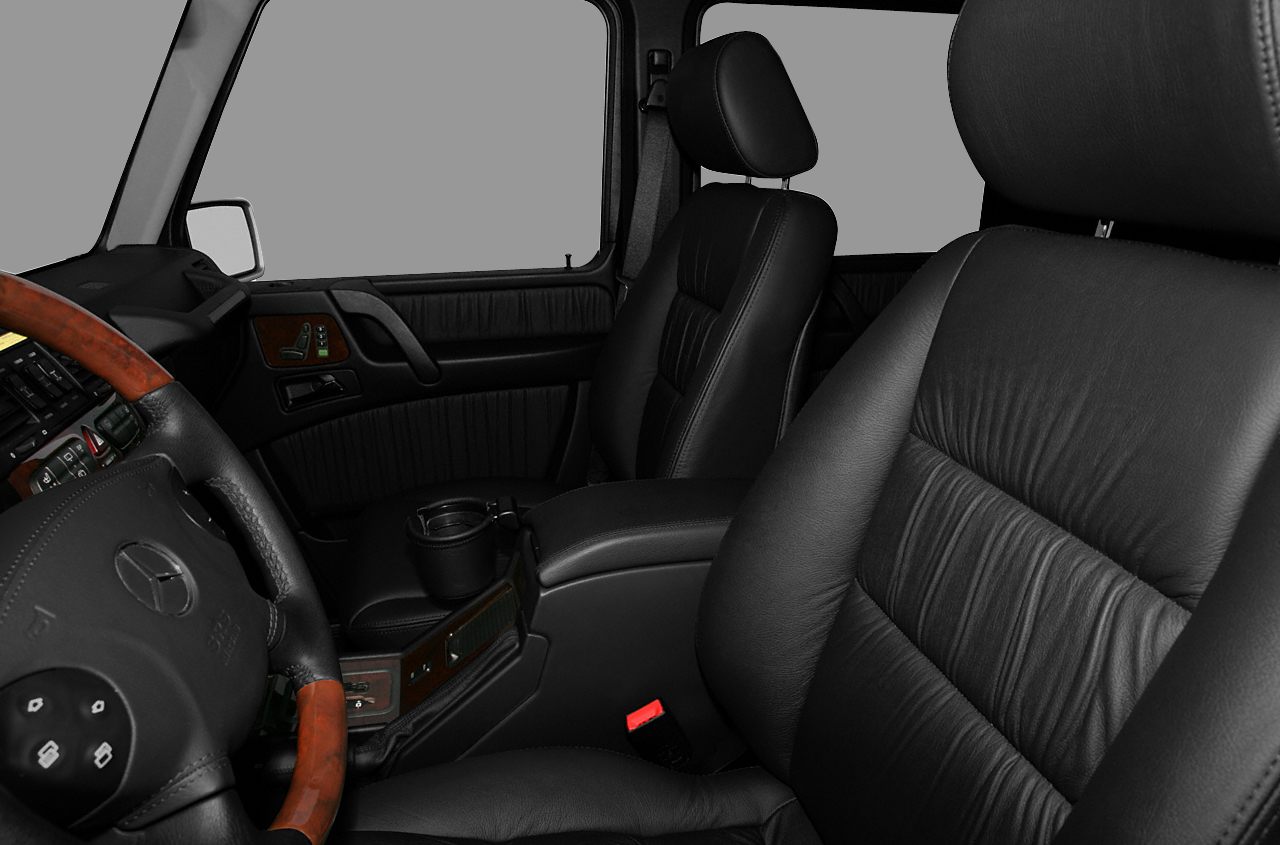 Black leather seats and wood-trimmed steering wheel with detailed cabin interior