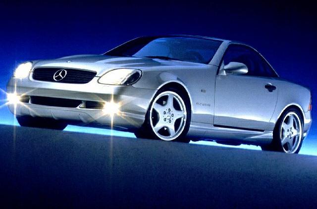 Silver front side view of a roadster with headlights on