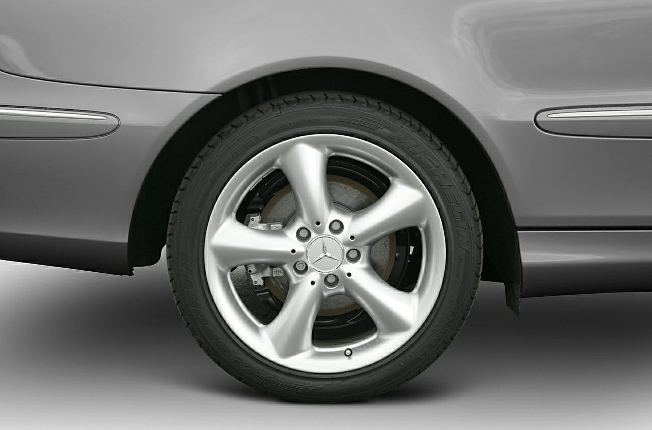 Close-up of 5-spoke alloy wheel with visible brake disc and tire on a luxury vehicle