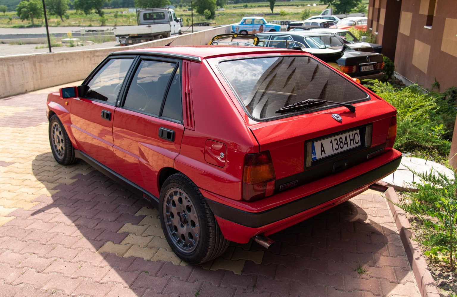 Red hatchback rear with alloy wheels and rear windshield wiper