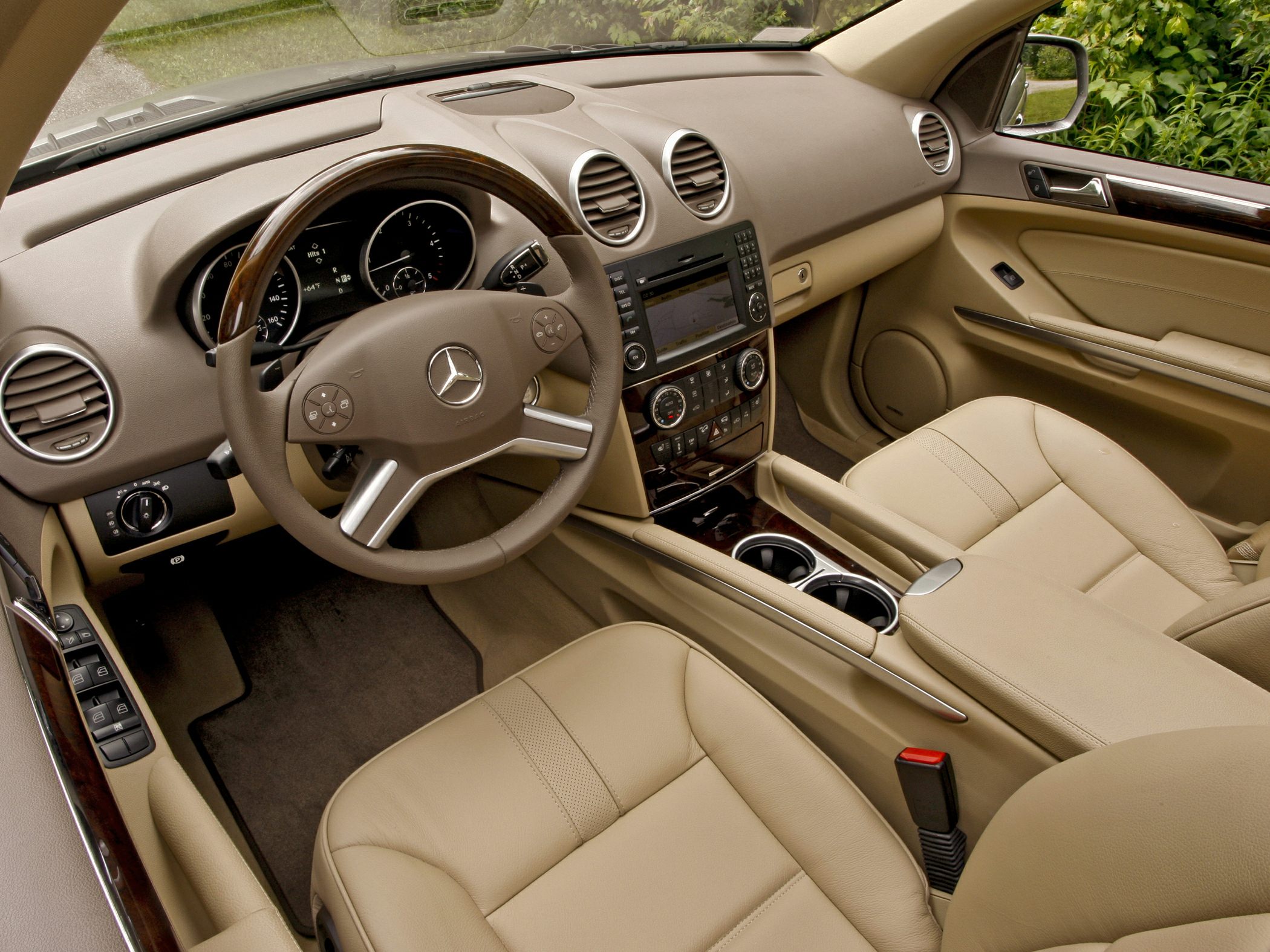 Beige leather seats and advanced dashboard with multifunction steering wheel.