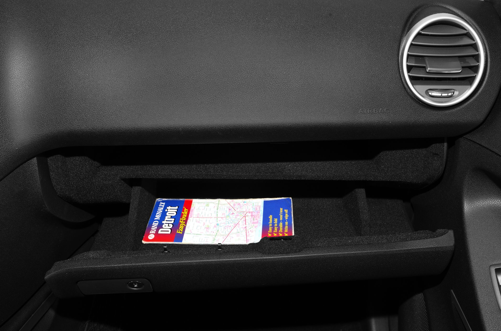 Open glove box with dashboard air vent on passenger side