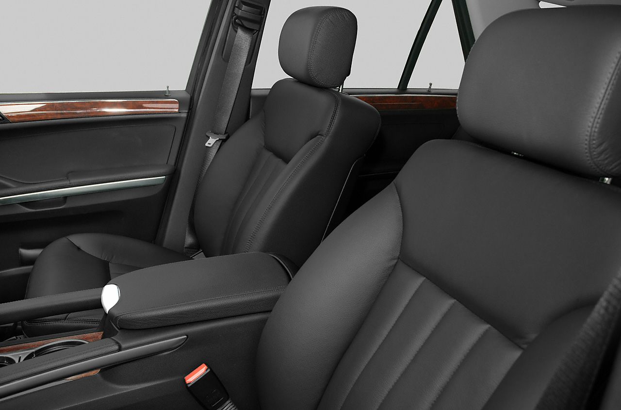 Black leather seats and wood trim interior with armrest and seatbelt