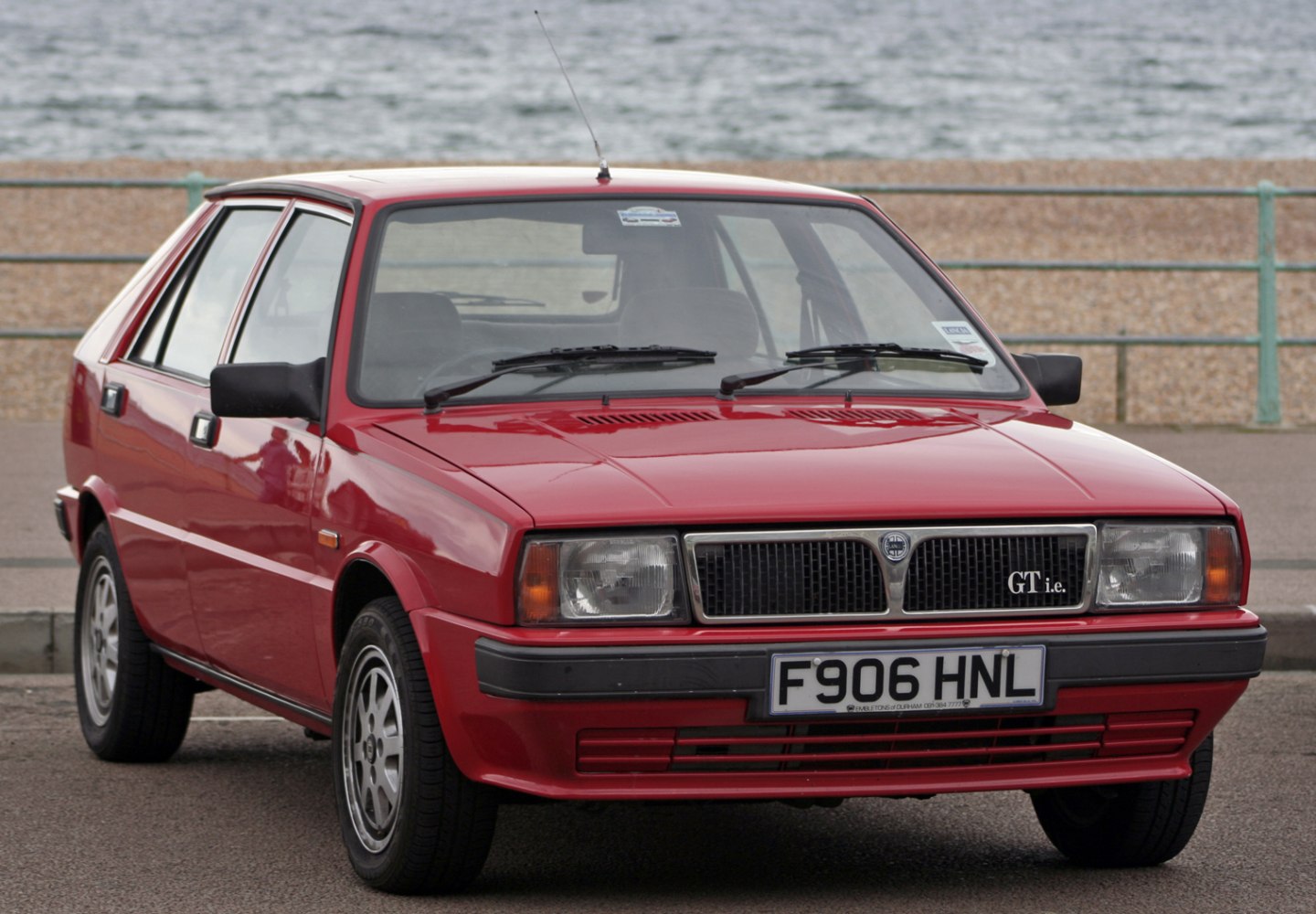 Front view of a red 1980s hatchback with distinctive grille and headlights
