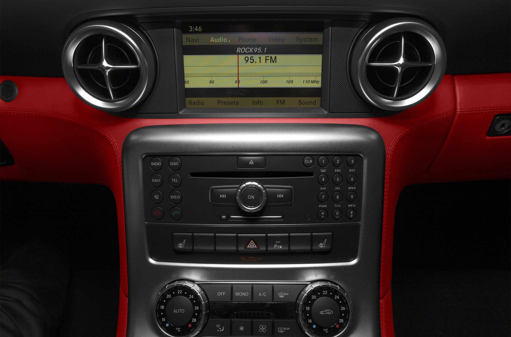 Close-up of luxury infotainment and climate controls with red leather interior