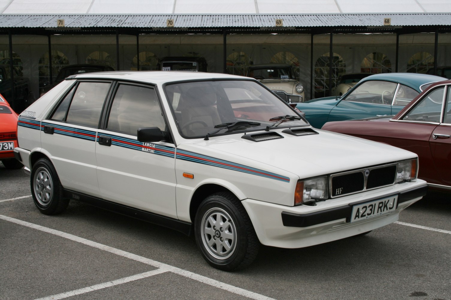 White hatchback with Martini racing stripes and dual hood vents