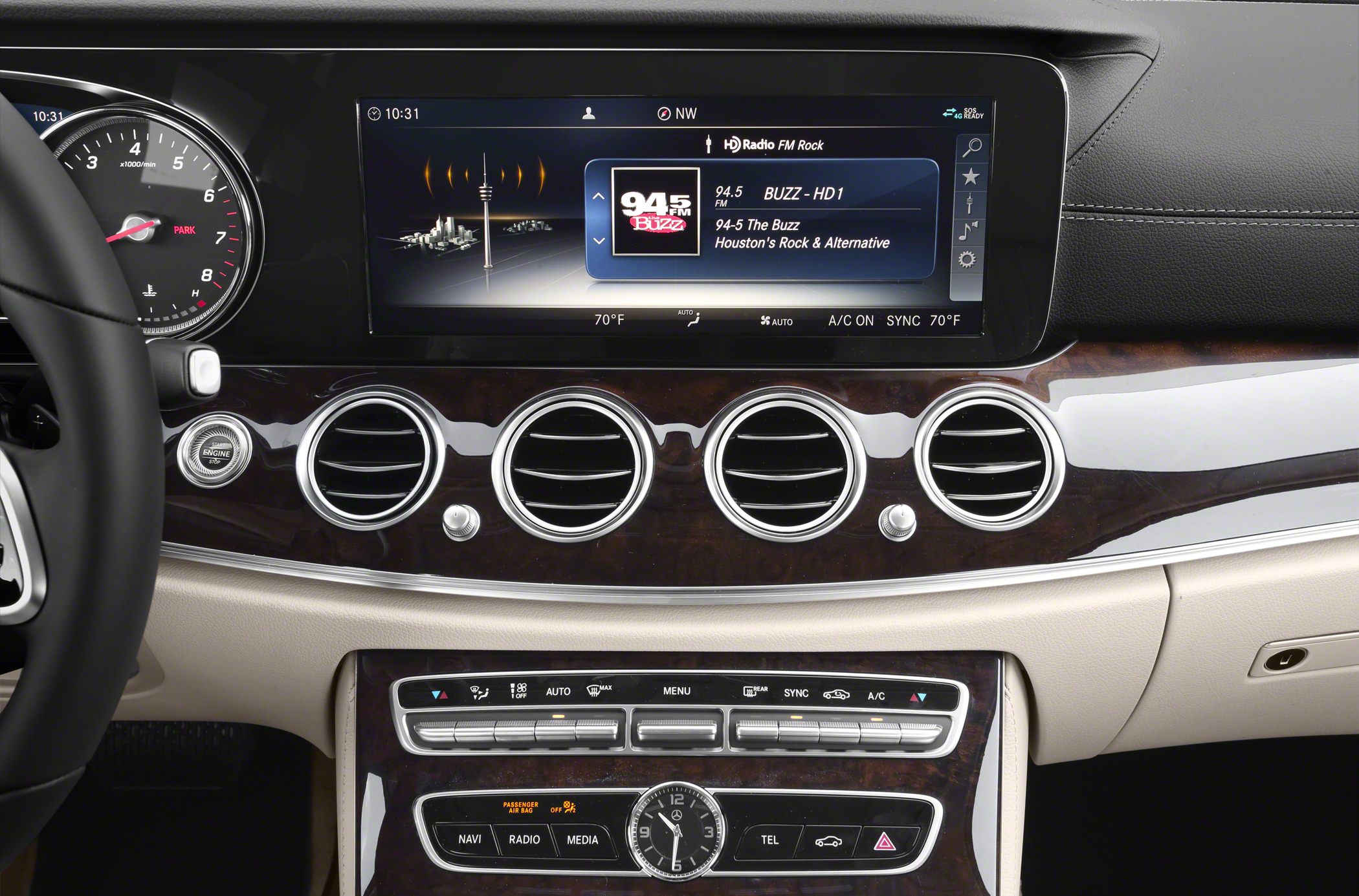 Infotainment screen and climate controls with analog clock in luxury car dashboard