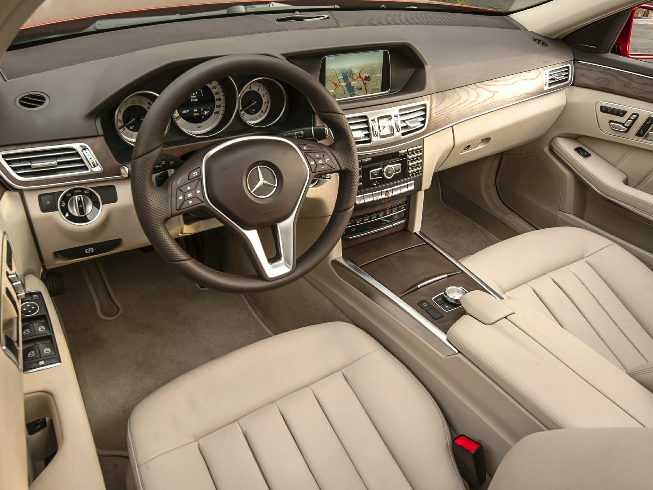 Luxury beige leather seats with wood trim dashboard and digital navigation display