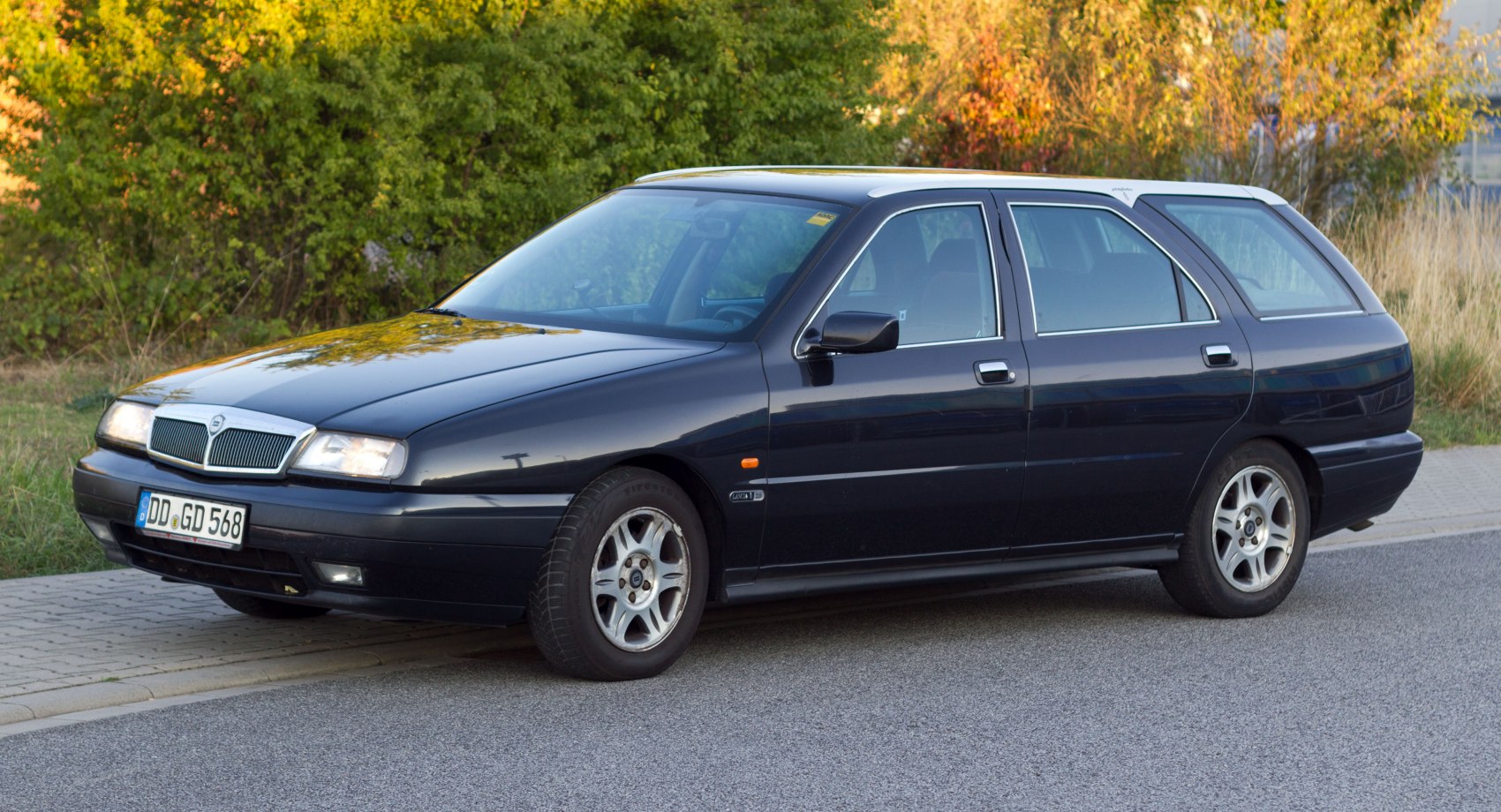 Side and front view of a sleek classic station wagon with alloy wheels.