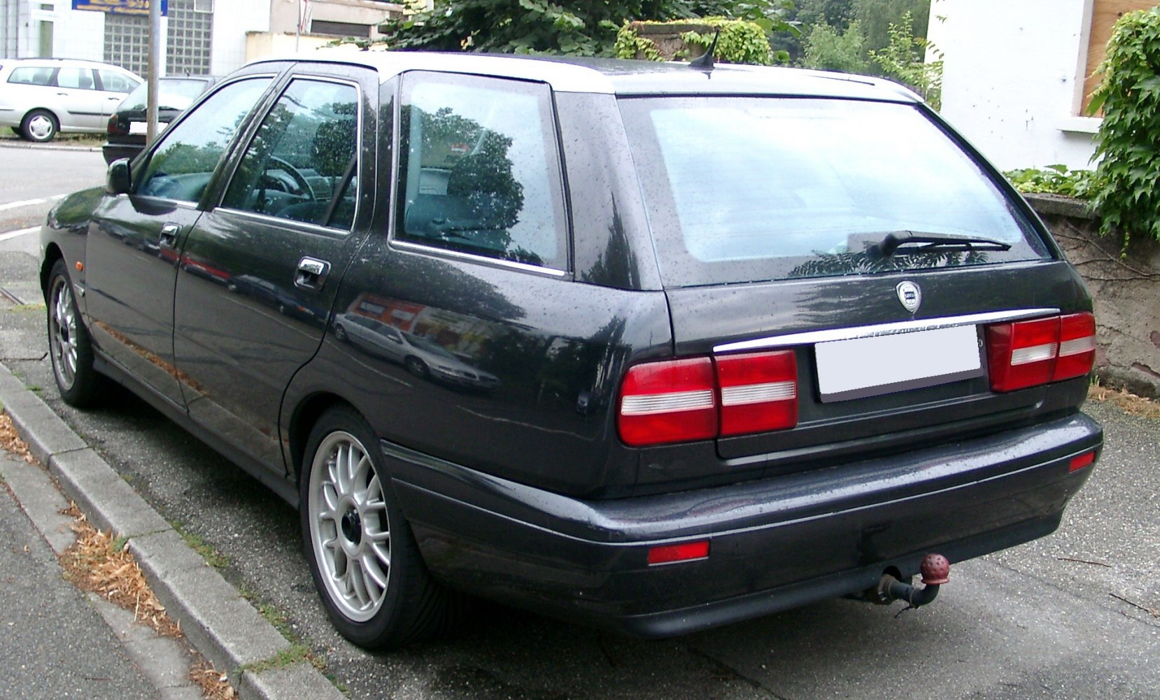Rear and side view of station wagon with alloy wheels and rear hatch.