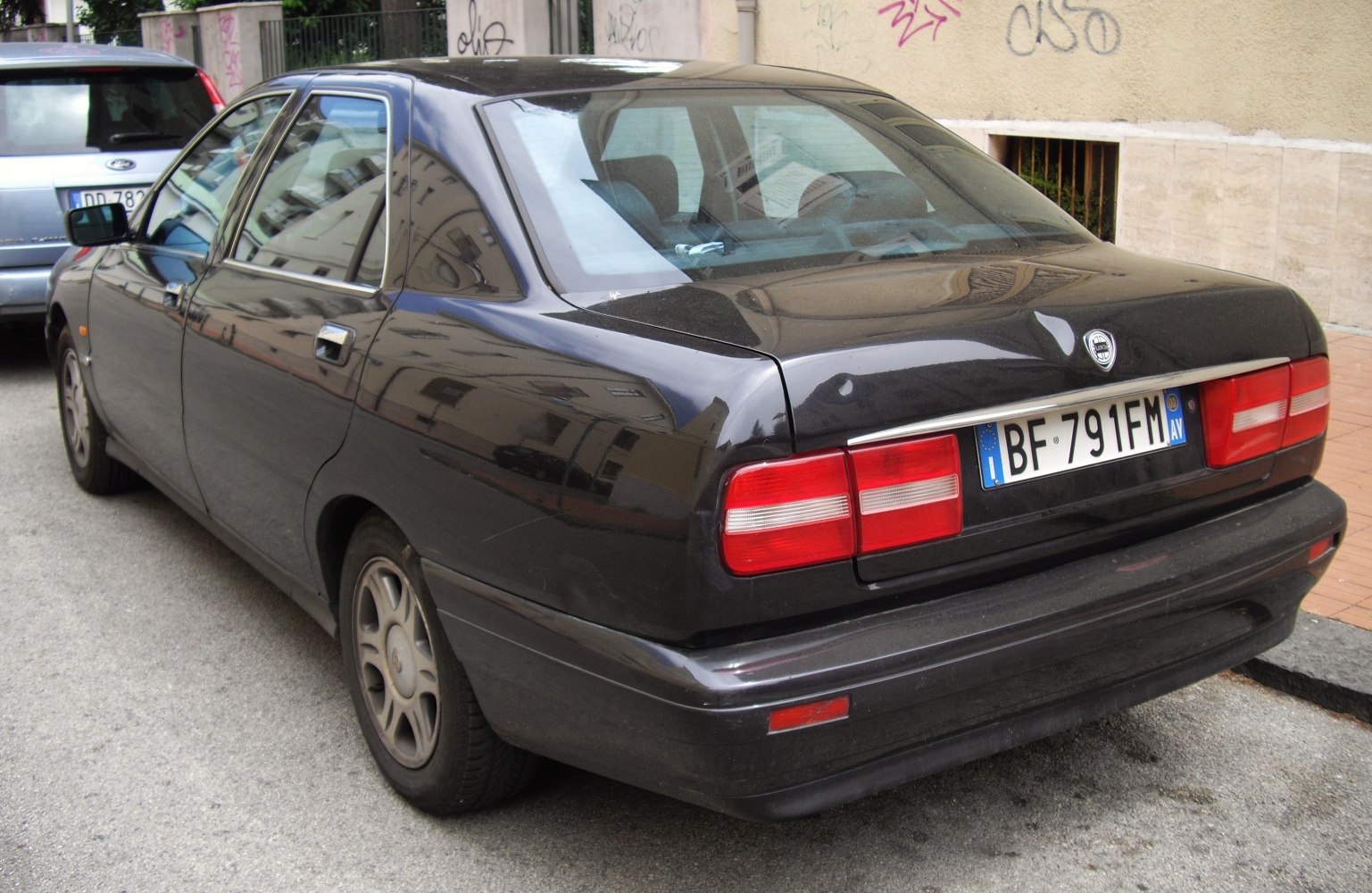 Rear view of a four-door sedan with rectangular tail lights and a smooth rear bumper.