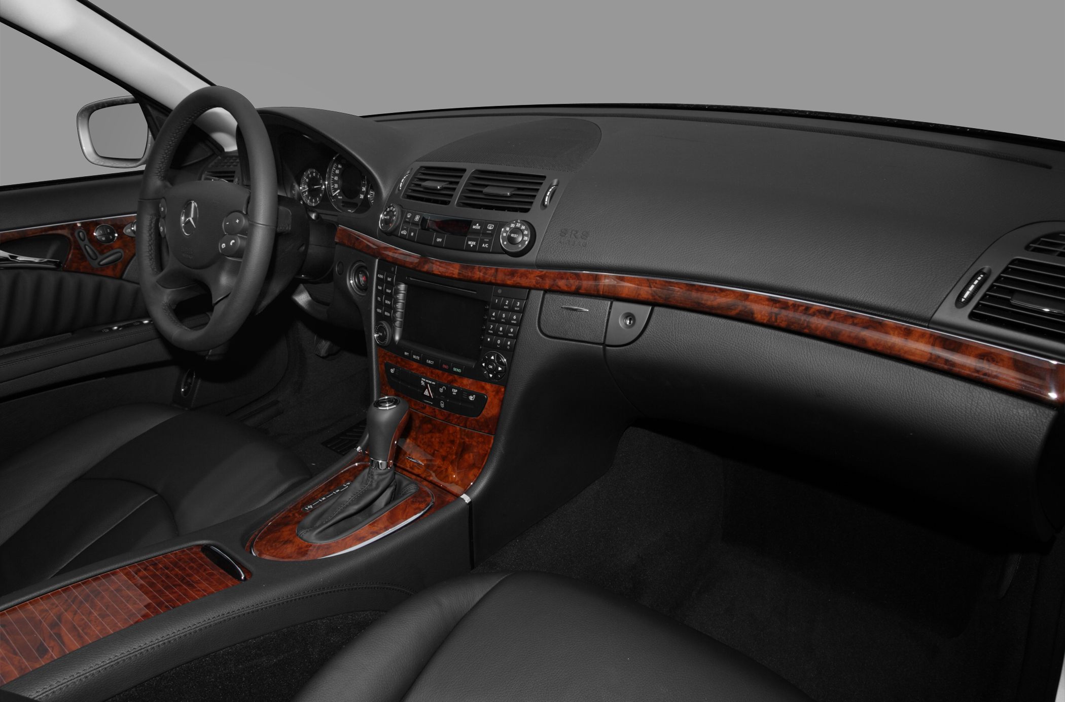 Luxury car interior with wood trim and leather seats.