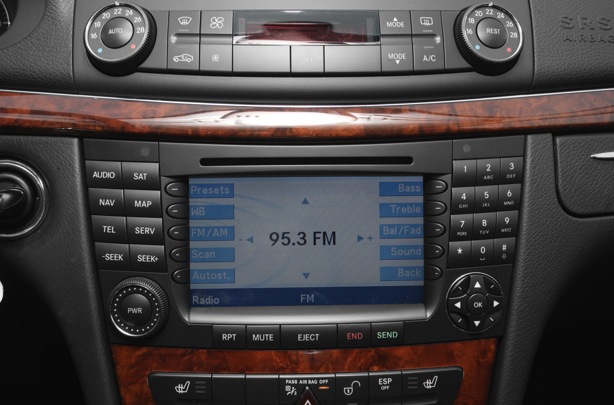 Dashboard radio and multimedia control with wood trim.