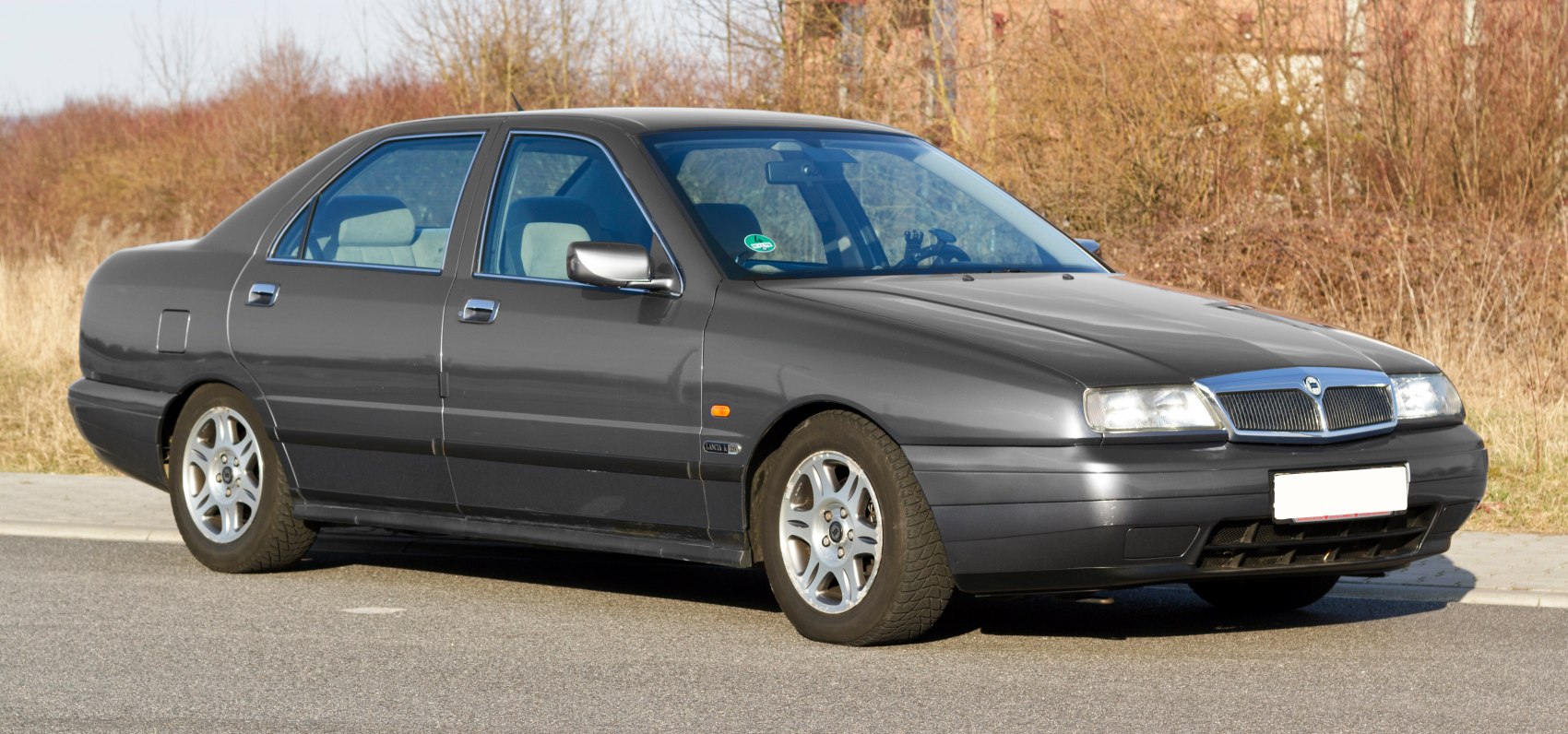 Side-front view of a sleek four-door sedan with alloy wheels