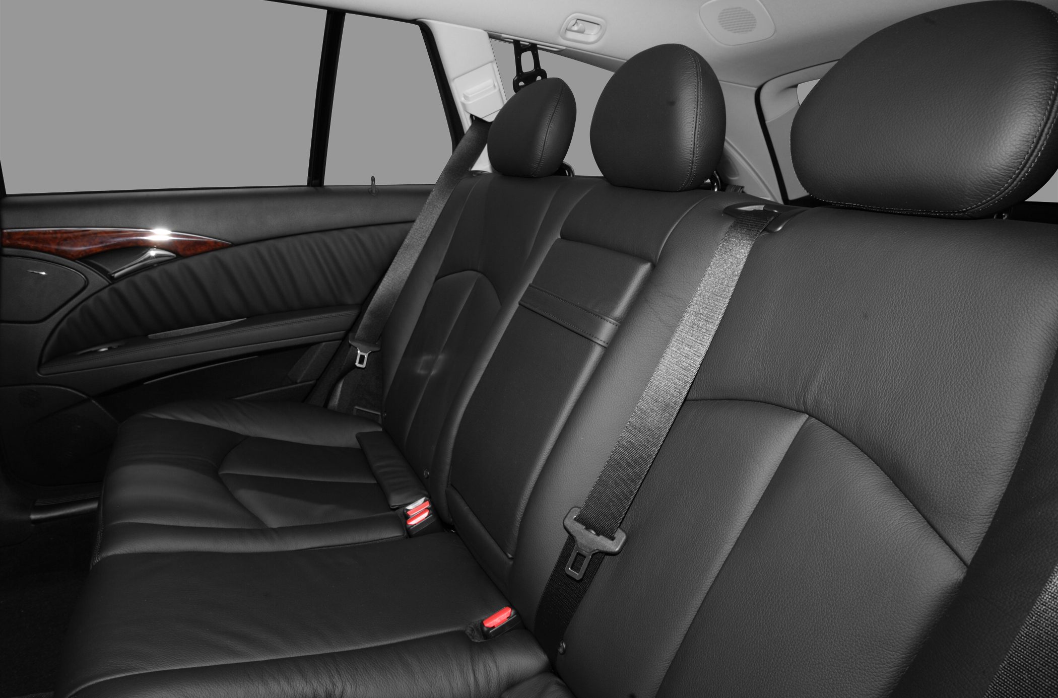 Black leather rear seat interior with seat belts and wood trim