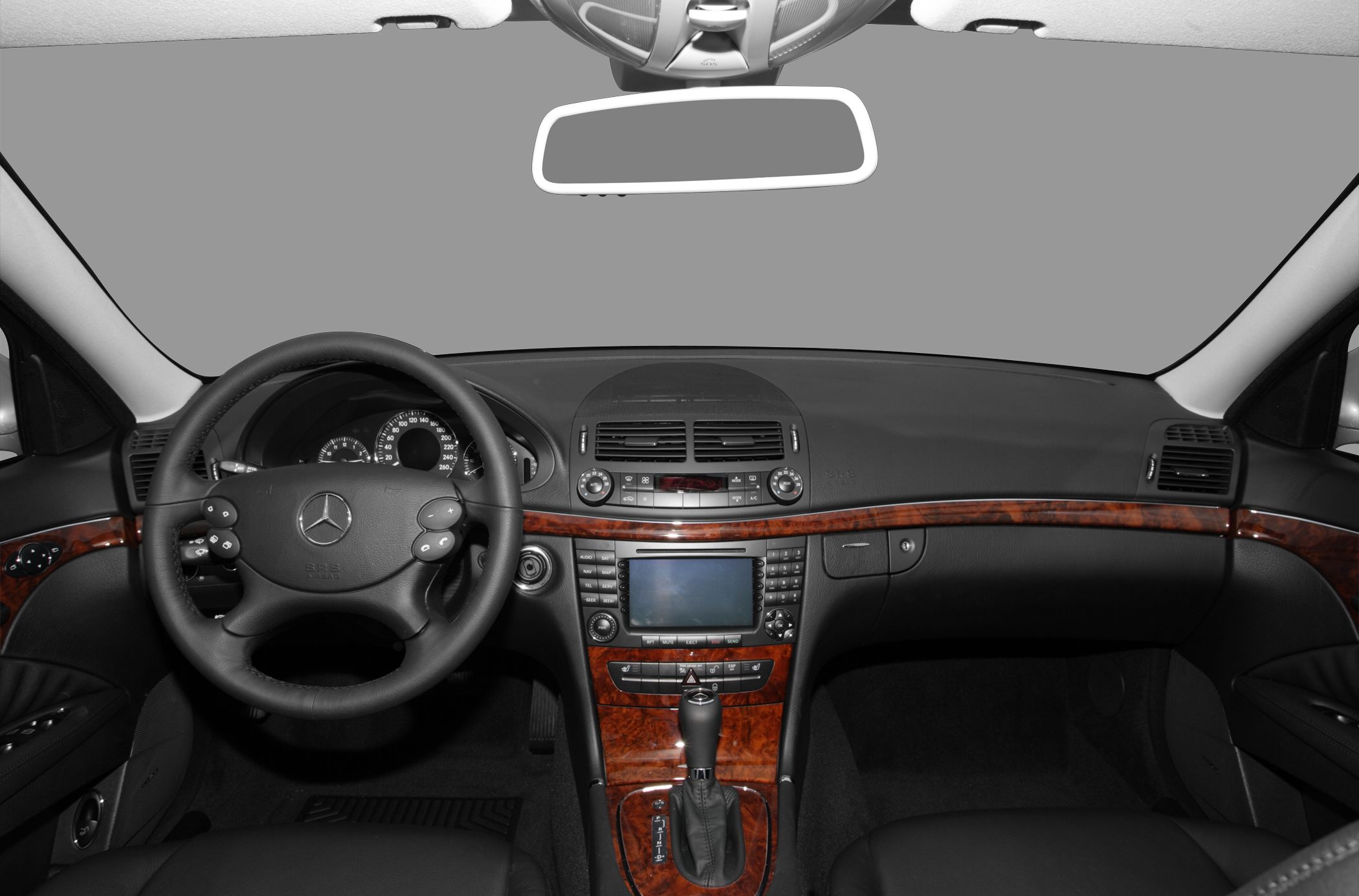 Dashboard and steering wheel with wood trim and central console.