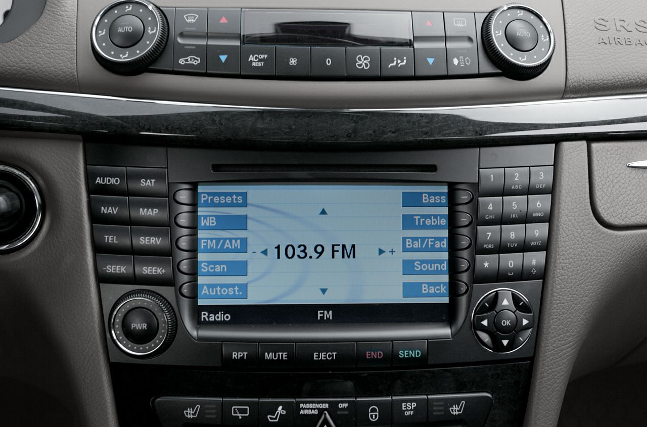 Radio and climate control panel with button layout and digital display