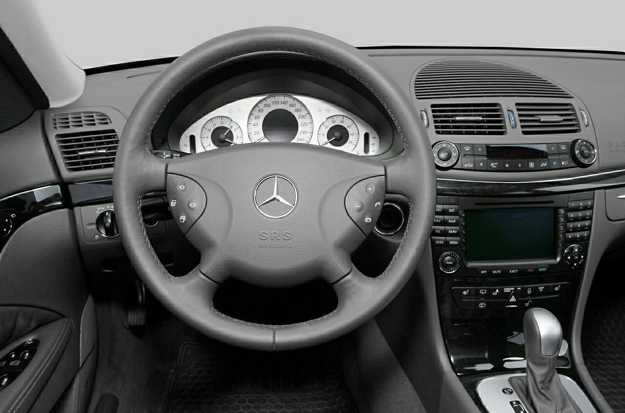 Steering wheel and dashboard with instrument cluster and center console controls.